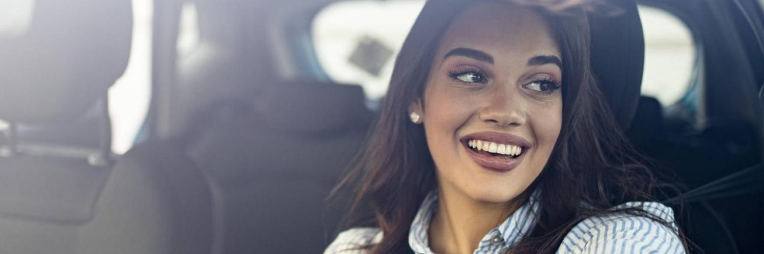 Woman smiling behind the steering wheel