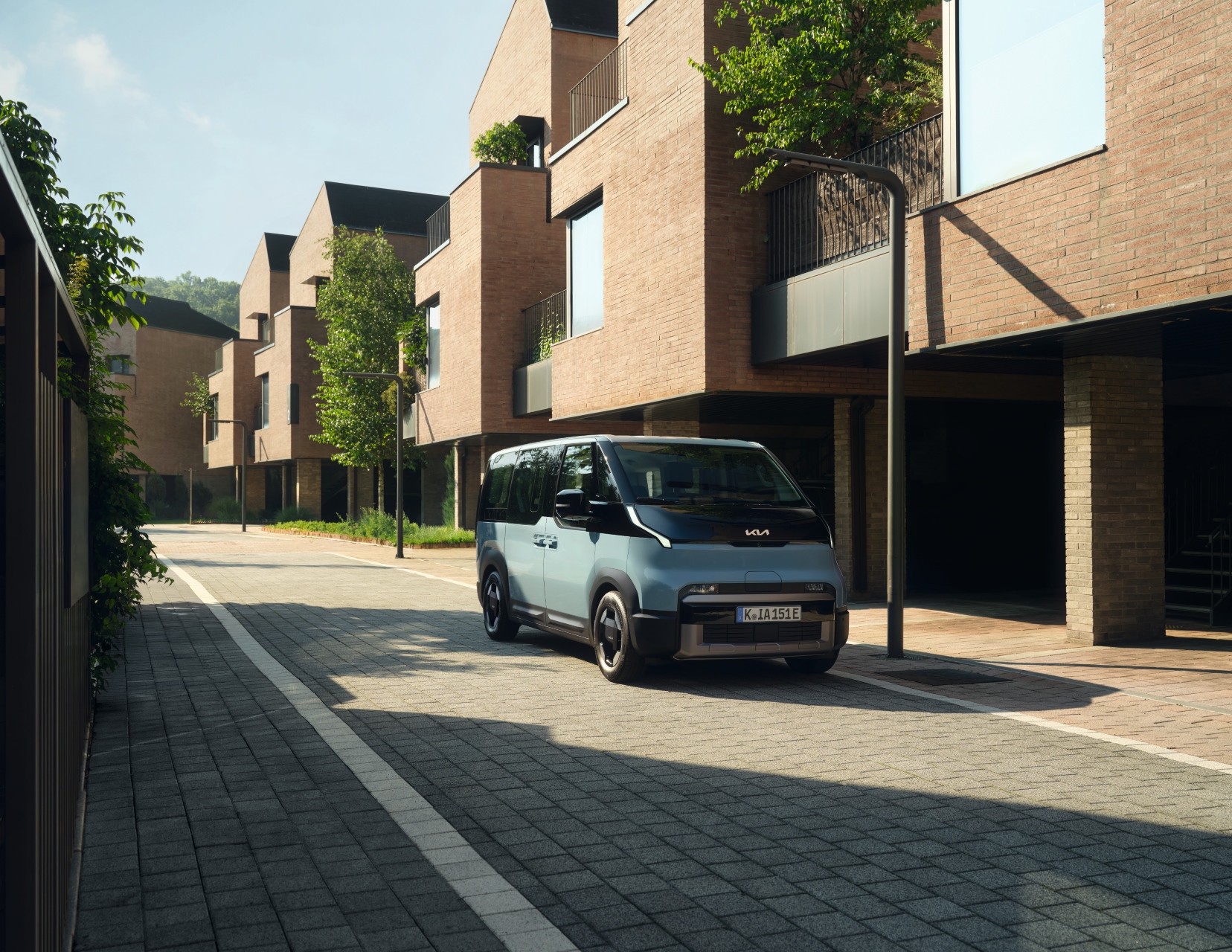 A PV5 Passenger parked in the street between two apartment buildings