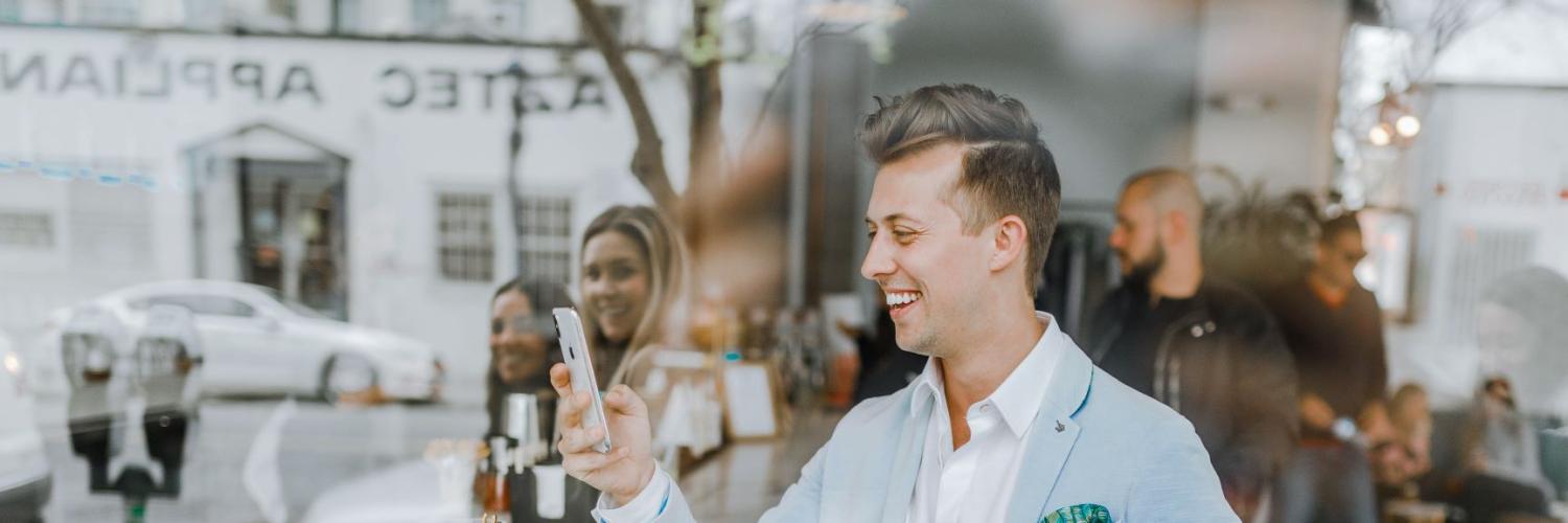 A man smiling at his phone