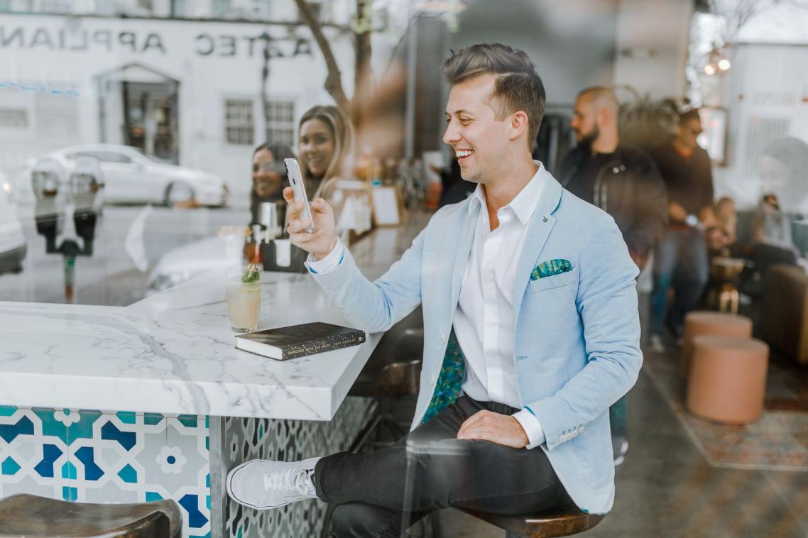 A man smiling at his phone